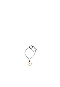 Collar de cordón negro con un colgante en forma de corazón dorado con un acabado texturizado, asegurado con un lazo ajustable y acentos dorados en los extremos.