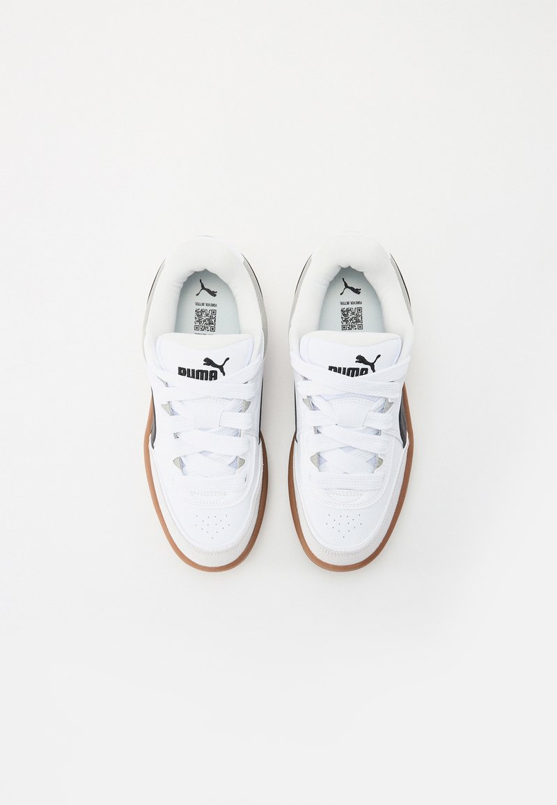 Sneakers bianchi con tomaia in pelle texturizzata, design con lacci, suola in gomma e logo Puma nero sul lato. Interno con rivestimento morbido.