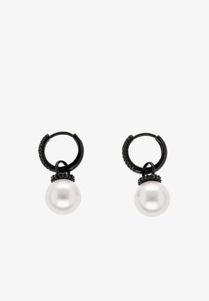 Par sorte øreringe med små sorte sten og store hvide perlevedhæng, der hænger fra hver ørering.