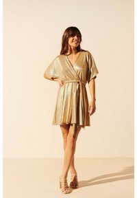Robe enveloppante dorée scintillante avec de courtes manches kimono et une ceinture ajustée à la taille, présentant une jupe fluide et une texture douce.