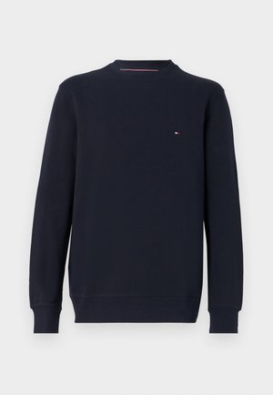 Sweatshirt azul-marinho feito de algodão, com gola redonda, mangas compridas e um pequeno logotipo bordado no peito. Textura suave.