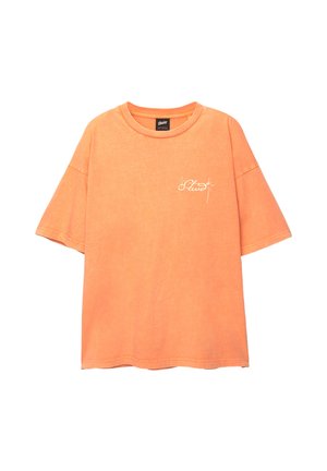 Oranges Baumwoll-T-Shirt mit lockerer Passform, kurzen Ärmeln und rundem Halsausschnitt. Engagierte weiße Schriftzug-Logo auf der Vorderseite.