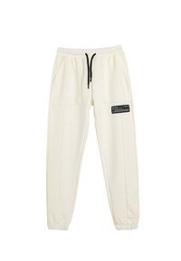 Cremefarvede joggers lavet af blødt stof, med elastisk talje med snoretræk, to store sidelommer og en sort labeldetalje.
