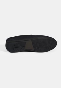 Schwarze Sneaker-Sohle mit einem strukturierten Design, versehen mit einer gummierten, rutschfesten Oberfläche und geometrischem Profilmuster für besseren Halt.