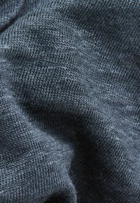 Donker marineblauw gebreide stof met een gladde textuur. Het materiaal lijkt zacht en licht elastisch, met een consistente, fijne weefpatroon.