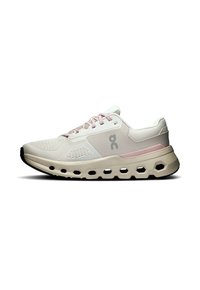 Lichtbeige en roze hardloopschoen met ademend mesh bovenwerk, gevoerde zool met holle hexagonale uitsparingen en een logo aan de zijkant.