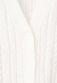 Cárdigan blanco de punto con escote en V, patrón de cable y pequeños botones redondos. Textura suave y apariencia cálida.