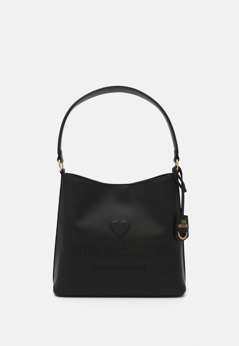 Črna torbica iz umetnega usnja s krušno obliko, s fantazijskim logotipom, detajlom srca in odstranljivo privlačnico. Ima en sam naramni trak.