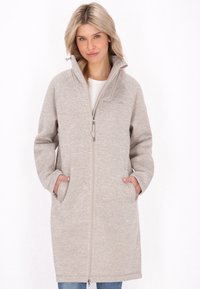 Beige kapucnis kabát, texturált anyagból készült, elöl cipzárral, oldal zsebekkel és laza szabással, amely a comb közepéig ér.