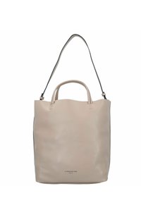 Beżowa skórzana torba typu tote z podwójnymi uchwytami u góry i odczepianym czarnym paskiem na ramię. Gładka tekstura, minimalistyczny design, z wytłoczonym logo.