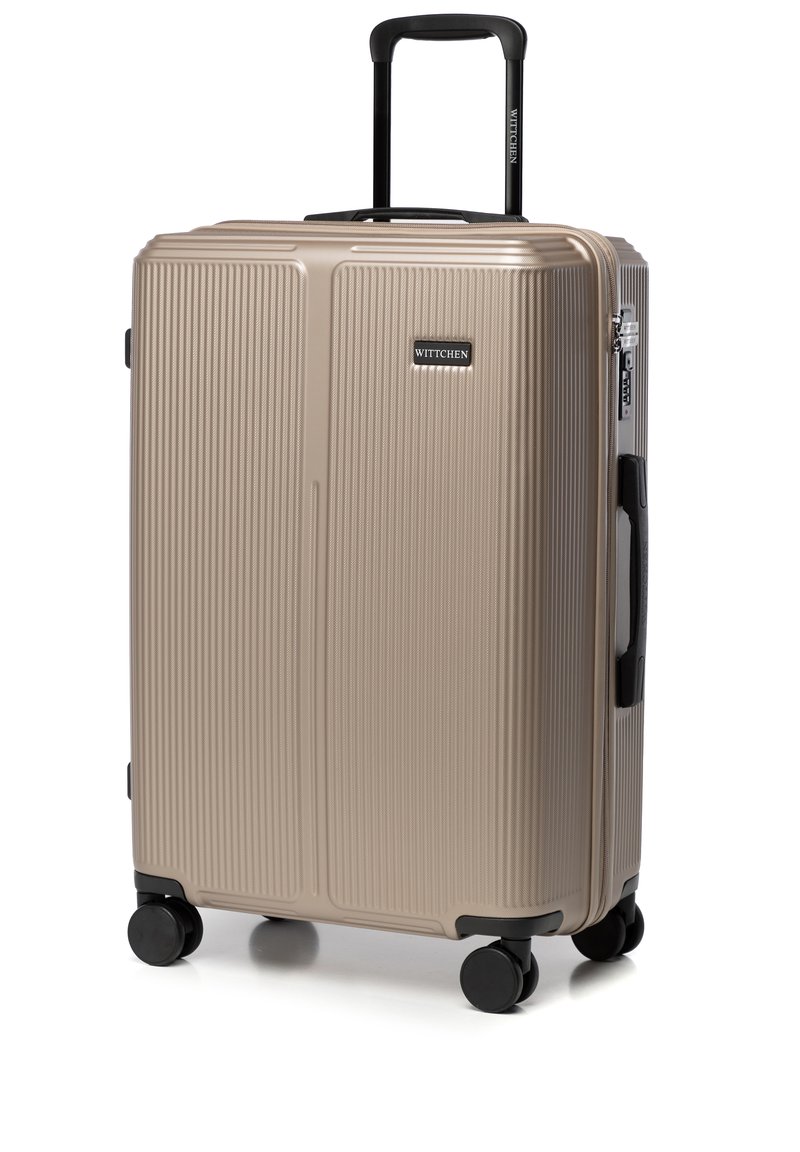 Valise rigide en beige métallique avec un design à rainures verticales, deux roues noires, une poignée rétractable et des accessoires de marque.