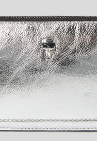 Portafoglio metallico argento in materiale sintetico texture, con un piccolo accento a forma di teschio con occhiali da sole. Include una chiusura con zip sulla parte superiore.