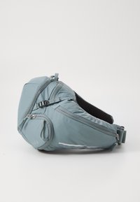 Light blue ergonomic backpack made of durable fabric, featuring multiple zippers, reflective accents, and a padded back for comfort.