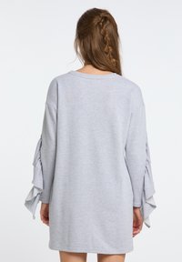 Helles graues, oversized Sweatshirt mit langen, rüschensleeves. Weicher Stoff, einfacher runder Ausschnitt und lässiges Design für angenehmen Tragekomfort.