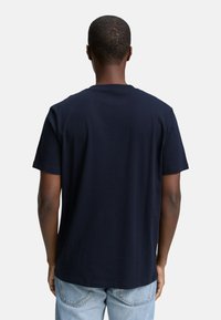 Marineblå bomulds t-shirt med rund hals, korte ærmer og en afslappet pasform, der har en glat tekstur og et enkelt design.