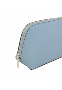 Jasnoniebieska torebka skórzana o fakturze, z złotym zamkiem i czarnymi wykończeniami. Posiada zaokrąglony kształt oraz mały detal z logo po boku.