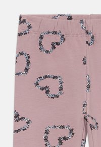 Støvete rosa leggings med elastisk midje som har et mønster av svarte og blå blomsterhjerter.
