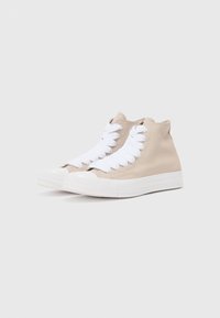 Adidași înalți din pânză bej cu șireturi albe, vârf rotunjit și talpă din cauciuc alb. Design simplu, cu un finisaj texturat.