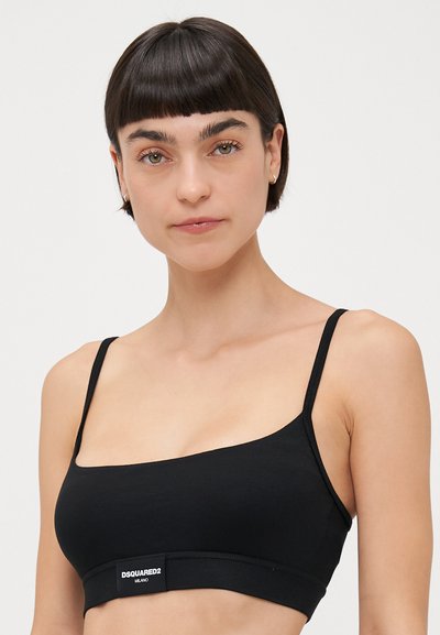 Black sports bra with thin straps, made of soft fabric, featuring a wide band with "DSQUARED2 MILANO" logo. Simple, unadorned design.