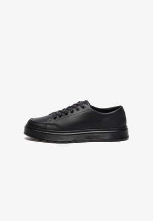 Black low-top sneakers made of smooth synthetic material, featuring round laces, six eyelets, and a textured rubber sole with white accents.