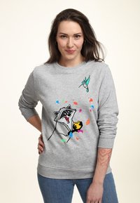 Grå sweatshirt med en tvättbjörnsgrafik som håller en kaka, med färgglada lövmönster och en kolibri-design på axeln.