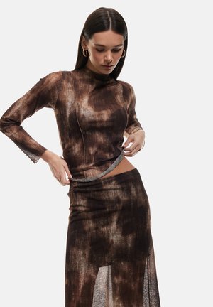 Braun gemustertes Zweiteiler-Outfit mit einem enganliegenden Langarmoberteil und einem Rock mit hohem Schlitz. Das Design bietet eine glatte Textur.