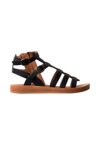 Sandale plate en cuir noir avec trois brides avant, deux boucles latérales réglables et une semelle en caoutchouc marron.