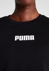 Felpa nera a girocollo con texture a costine, caratterizzata da un prominente logo "PUMA" bianco centrato sul petto.