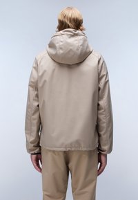 Beige, vattentät jacka med en stor huva, elastiska manschetter och slät yta. Enkelt design, punktseamsdetaljer och en avslappnad passform.