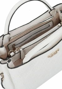 Sac à main blanc en cuir texturé avec plusieurs compartiments, ferrures argentées et un logo de marque doré embossé à l'avant.