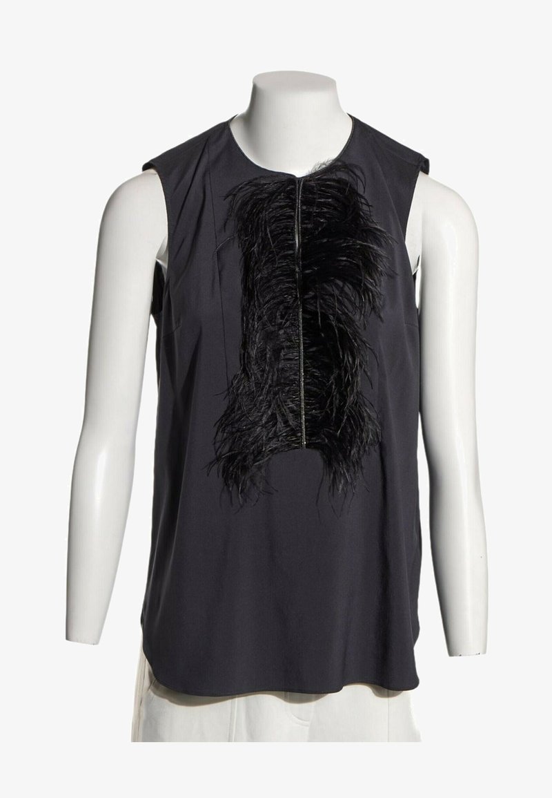 Blouse noire sans manches avec un panneau vertical central de plumes noires froncées, présentée sur un buste de mannequin blanc.