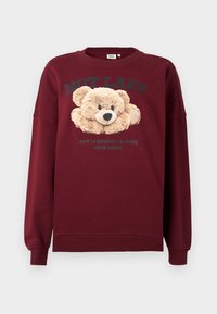 Maroon sweatshirt with teddy bear graphic and text "NOT LAZY" and "JUST IN ENERGY-SAVING BEAR MODE" on front, long sleeves, ribbed cuffs.