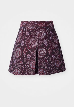 Jupe-culotte à motif floral en rouge profond et bleu sur un fond sombre, avec une silhouette évasée et un pli au dos pour un confort de mouvement.