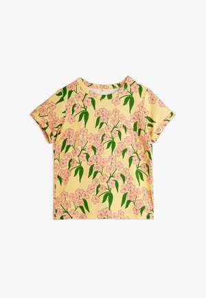 T-shirt amarela de mangas curtas com um padrão floral de flores cor-de-rosa e folhas verdes. Tecido de algodão macio com decote redondo.
