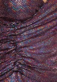 Tessuto nero con paillettes multicolori, caratterizzato da una texture arricciata e un motivo di decorazioni riflettenti circolari distribuite in tutto il tessuto.