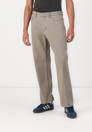 Beige gerade Jeans mit klassischem Fünf-Taschen-Design, aus Denim gefertigt, mit Metallschnalle und Reißverschluss.