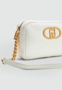 Bílá kožená crossbody taška s obdélníkovým tvarem, zlatým řetězovým kováním a metalickým logem na přední straně. Hladký povrch, zipové uzavírání.