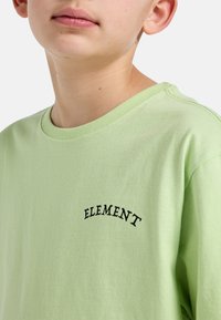 Kortærmet, lysegrøn bomulds t-shirt med ordet "ELEMENT" broderet i sort på brystet, rund halsudskæring og blød tekstur.