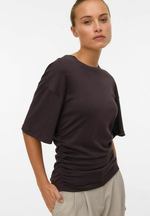 Haut court à manches courtes violet foncé avec des détails froncés sur les côtés, fabriqué en tissu doux ; sa coupe décontractée et son col rond se marient bien avec un pantalon tailleur.