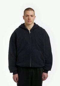 Dark blue zip-up hoodie made of thick fleece, featuring a textured front, large hood, and kangaroo pocket. Smooth interior texture.