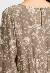 Braunes bl Floral-Muster-Kleid aus weichem Stoff, das einen Knopfverschluss auf der Rückseite und eine Raffung an den Ärmeln aufweist.