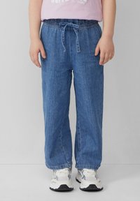 Pantalons en denim bleu clair avec une coupe décontractée, une taille élastique et un cordon de serrage ajustable. Détails de couture remarquables et poches latérales.
