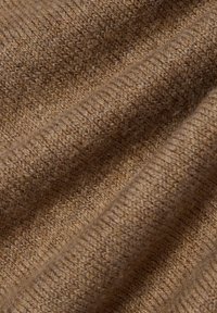 Strickstoff in warmem Braun mit strukturiertem, geripptem Muster. Das Material wirkt weich mit deutlich sichtbaren Fasern, die einen gemütlichen Eindruck vermitteln.