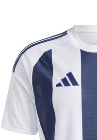 Adidas shirt met witte stof en marineblauwe accenten, inclusief verticale strepen en een textuurgedeelte. Klassieke ronde hals.