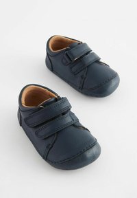 Marineblaue Leder-Kinderschuhe mit runder Zehenform, zwei Klettverschlüssen, beiger Innenauskleidung und genähten Details entlang der Kanten.