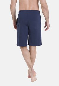Shorts pour hommes en coton bleu marine avec une ceinture élastique, arrivant à mi-cuisse, présentant une texture lisse sans motifs ni accents visibles.