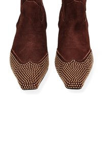 Stivaletti in suede marrone con punta appuntita, dotati di cuciture decorative e dettagli in oro sulla punta.
