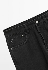 Jeans in denim nero con una texture liscia, design a cinque tasche, bottoni in metallo e taglio dritto. Toni scuri in tutto con dettagli minimi.