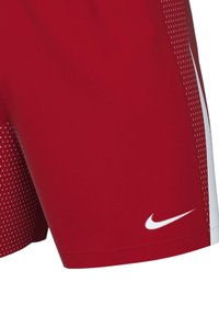 Rote Sportshorts mit weißen Akzenten, die eine glatte Textur und ein gepunktetes Muster auf der unteren Seite aufweisen. Nike-Logo in Weiß dargestellt.