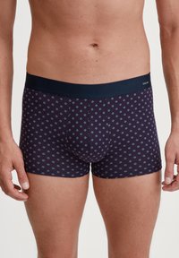 Boxer briefs made of soft fabric, featuring a dark navy waistband. The fabric has a geometric diamond pattern in light blue and burgundy.